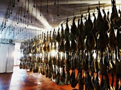 What distinguishes a natural Serrano ham from one with preservatives?